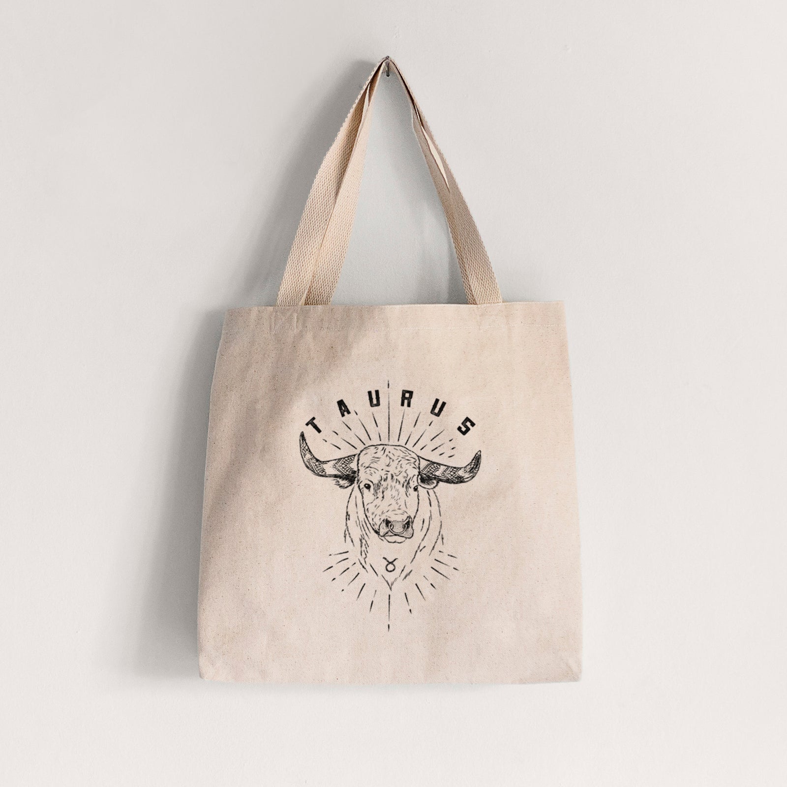 Natural canvas tote bag printed with a black ink bull's head with the word Taurus, for the Taurus zodiac sign.