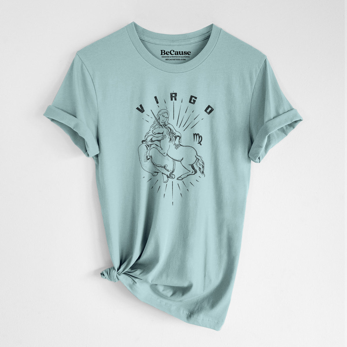 Dusty blue lightweight cotton t-shirt laid flat with the sleeves rolled, printed with a black ink woman holding wheat with the word Virgo, for the Virgo zodiac sign.