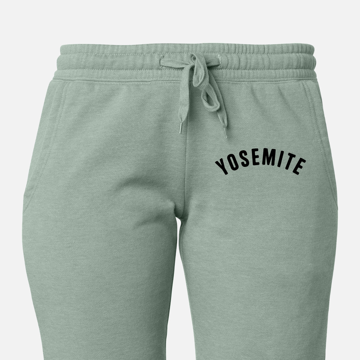 Front of sage green Cali Wave sweatpants, printed with the word Yosemite in bold black letters arched across the chest on the leg.
