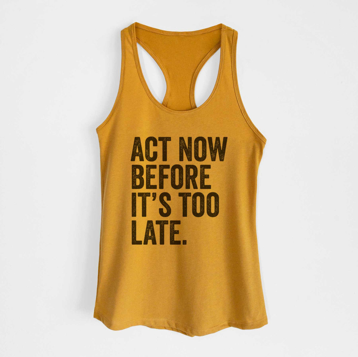 Gold women's racerback tank top laid flat, printed with bold black words reading Act Now Before It's Too Late.