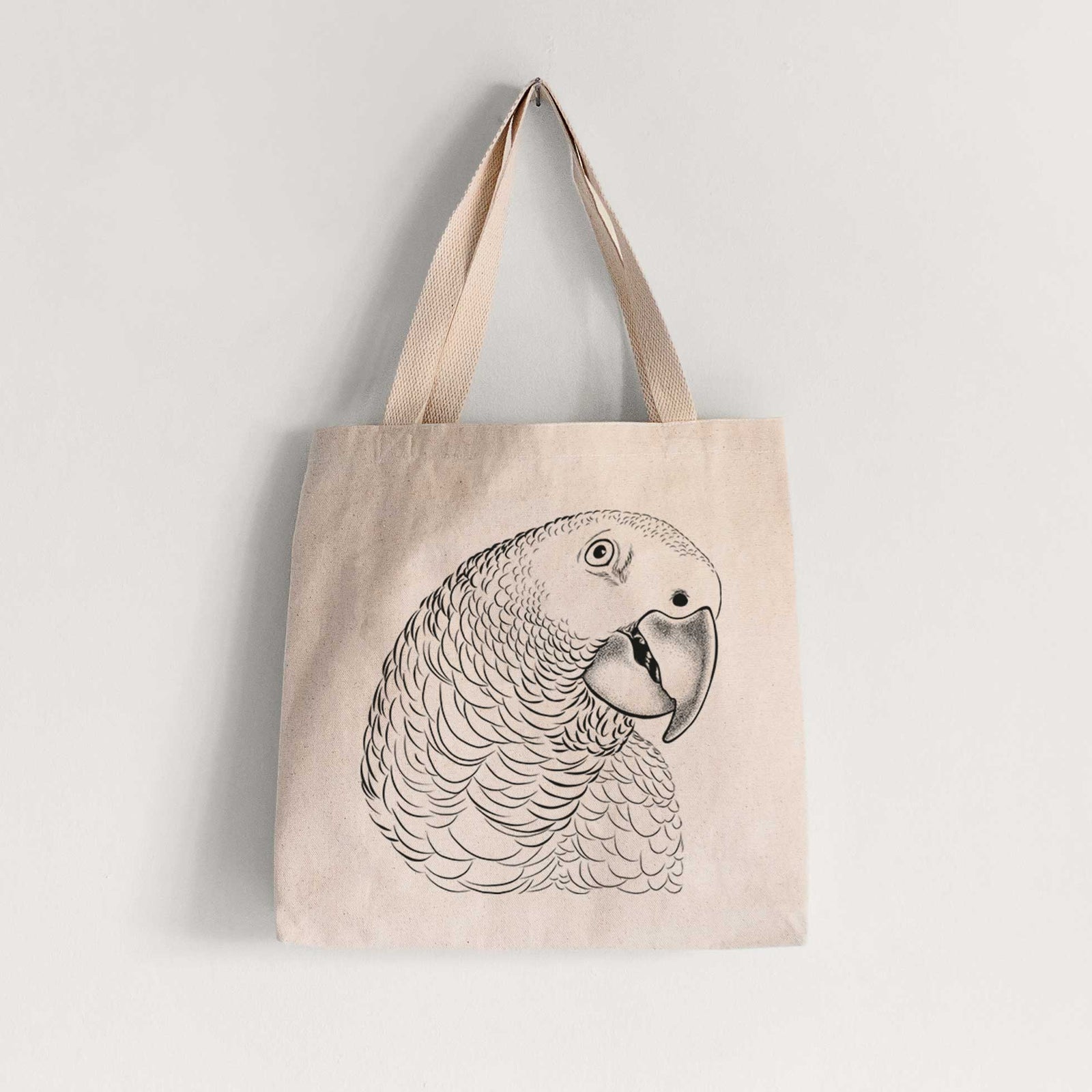Natural canvas tote bag printed with a detailed black ink portrait of an African grey parrot's head.