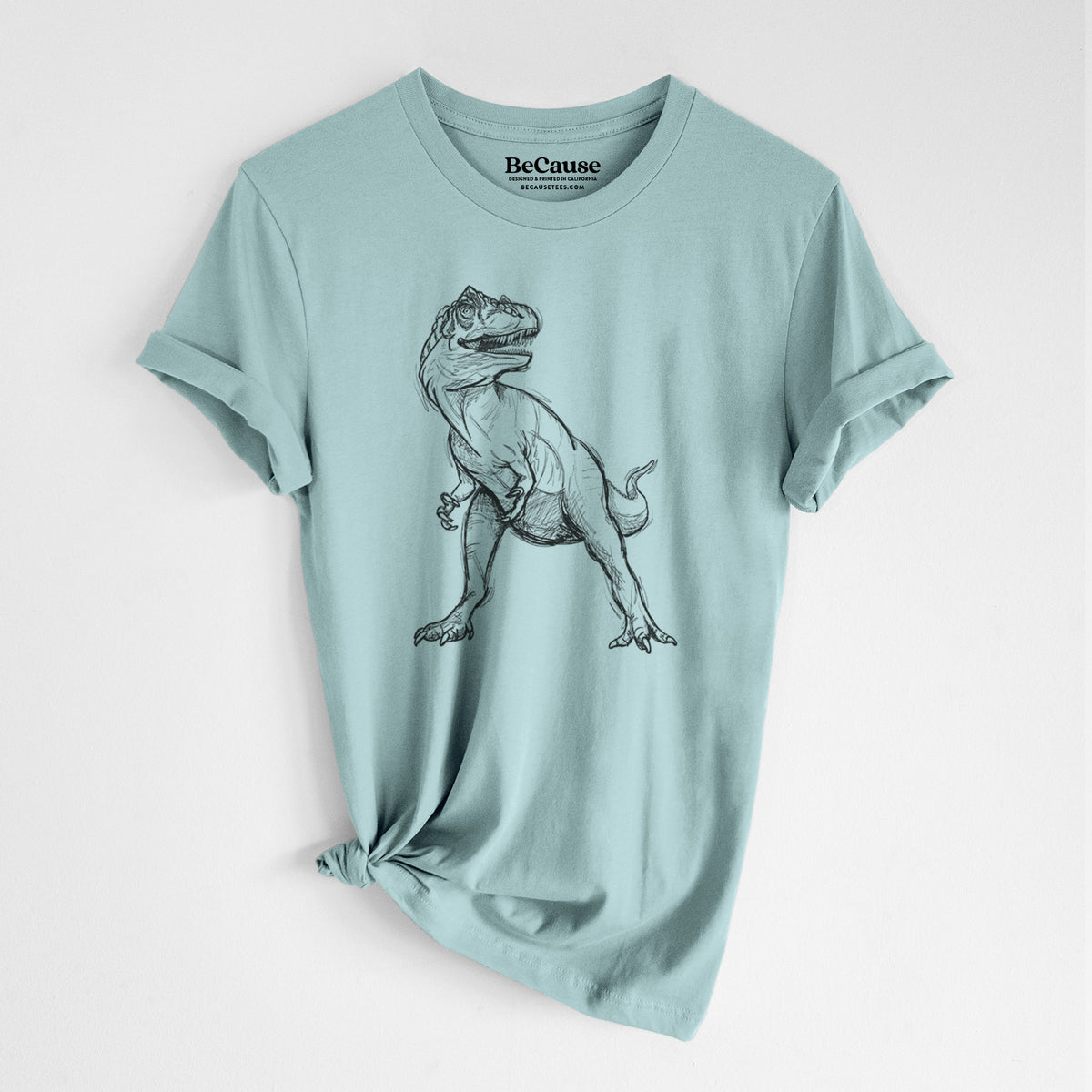 Dusty blue lightweight cotton t-shirt laid flat with the sleeves rolled, printed with a black ink illustration of an Allosaurus walking.