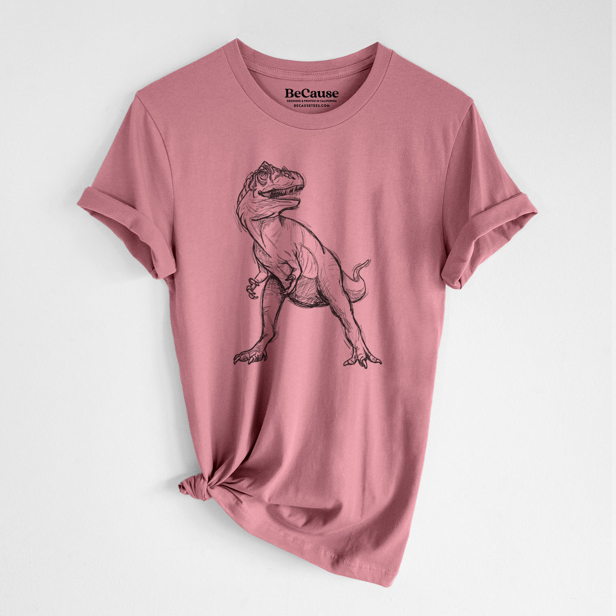 Mauve pink lightweight cotton t-shirt laid flat with the sleeves rolled, printed with a black ink illustration of an Allosaurus walking.