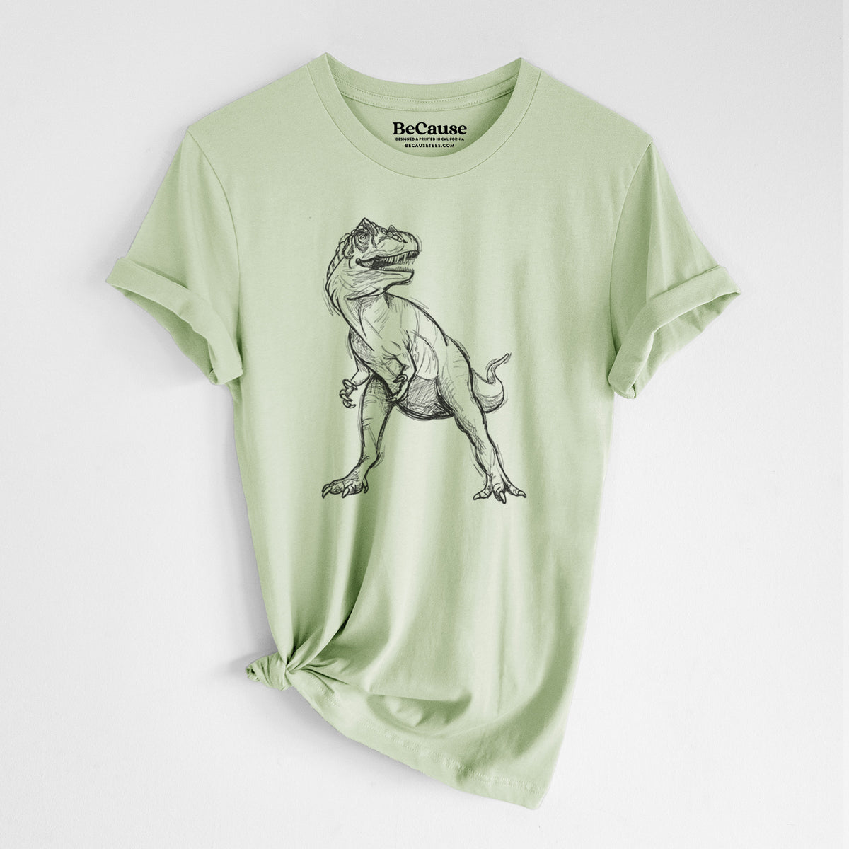 Spring green lightweight cotton t-shirt laid flat with the sleeves rolled, printed with a black ink illustration of an Allosaurus walking.