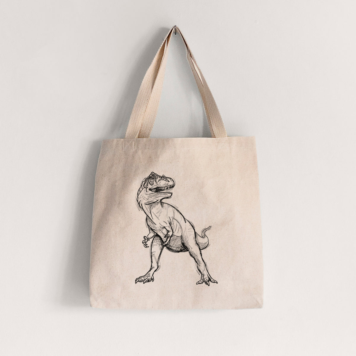 Natural canvas tote bag printed with a black ink illustration of an Allosaurus walking.