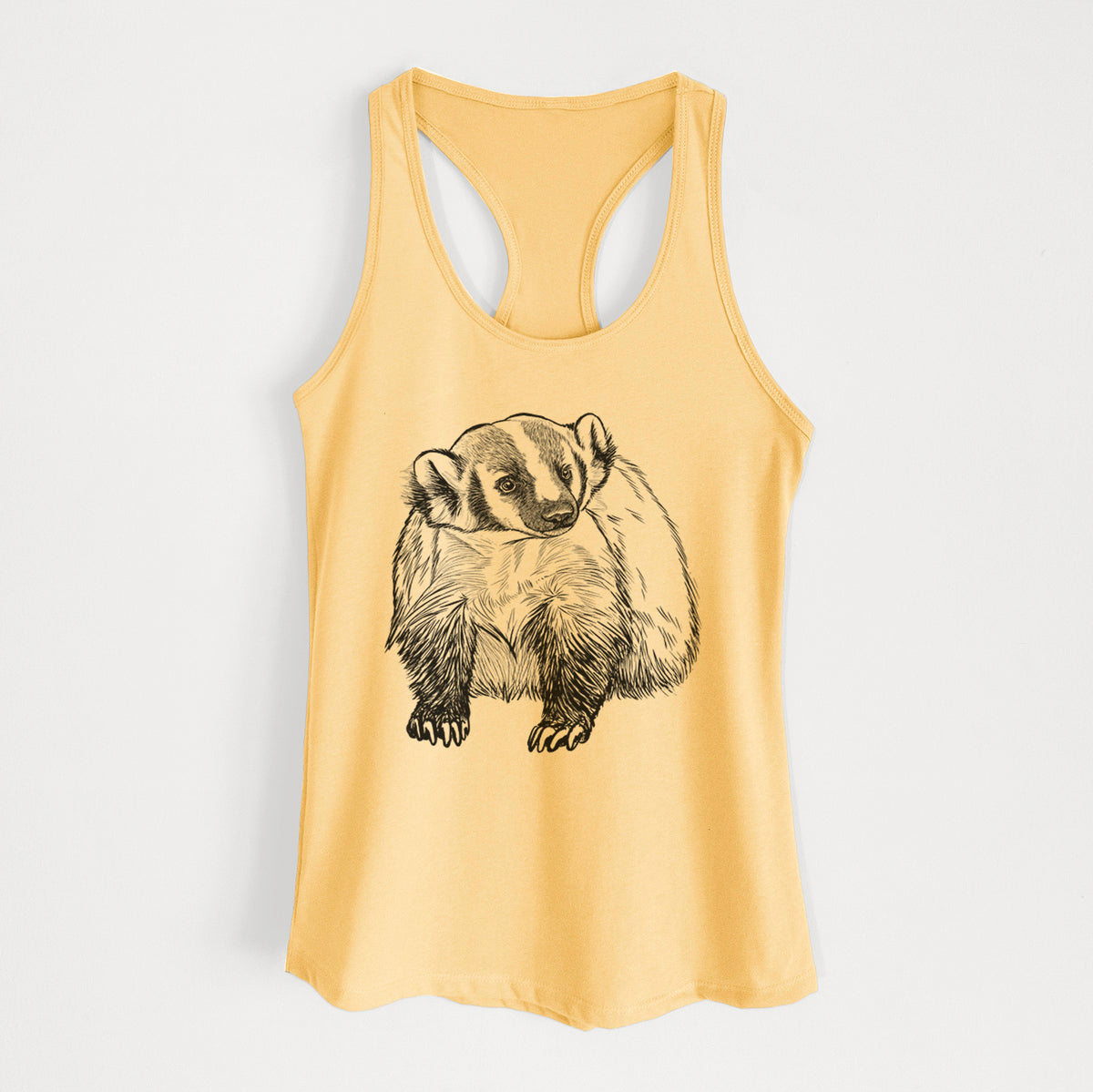 Banana cream women's racerback tank top laid flat, printed with a detailed black ink illustration of an American badger facing forward.