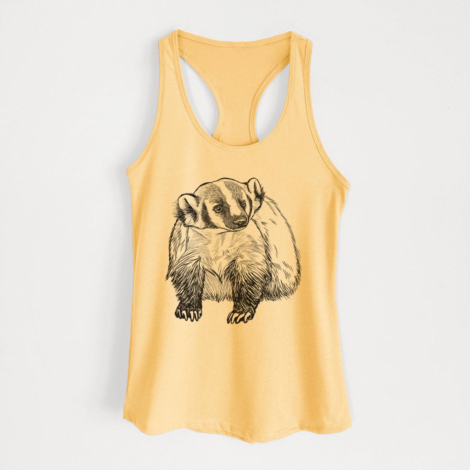 Banana cream women's racerback tank top laid flat, printed with a detailed black ink illustration of an American badger facing forward.