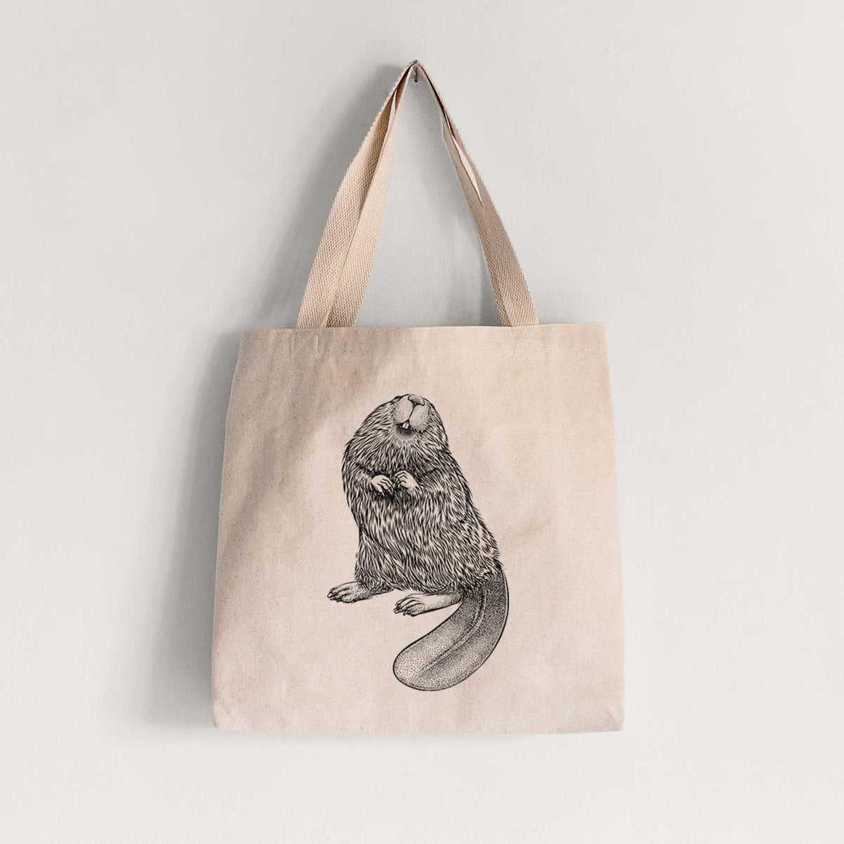 Natural canvas tote bag printed with a detailed black ink illustration of an American beaver sitting upright with its flat tail.