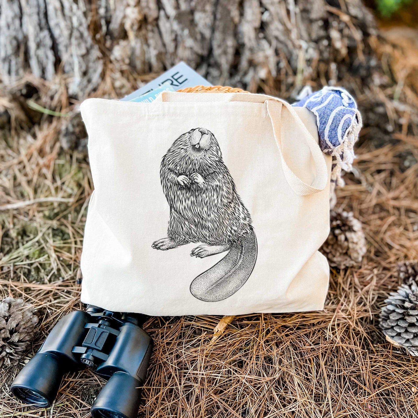 Natural canvas tote bag printed with a detailed black ink illustration of an American beaver sitting upright with its flat tail.