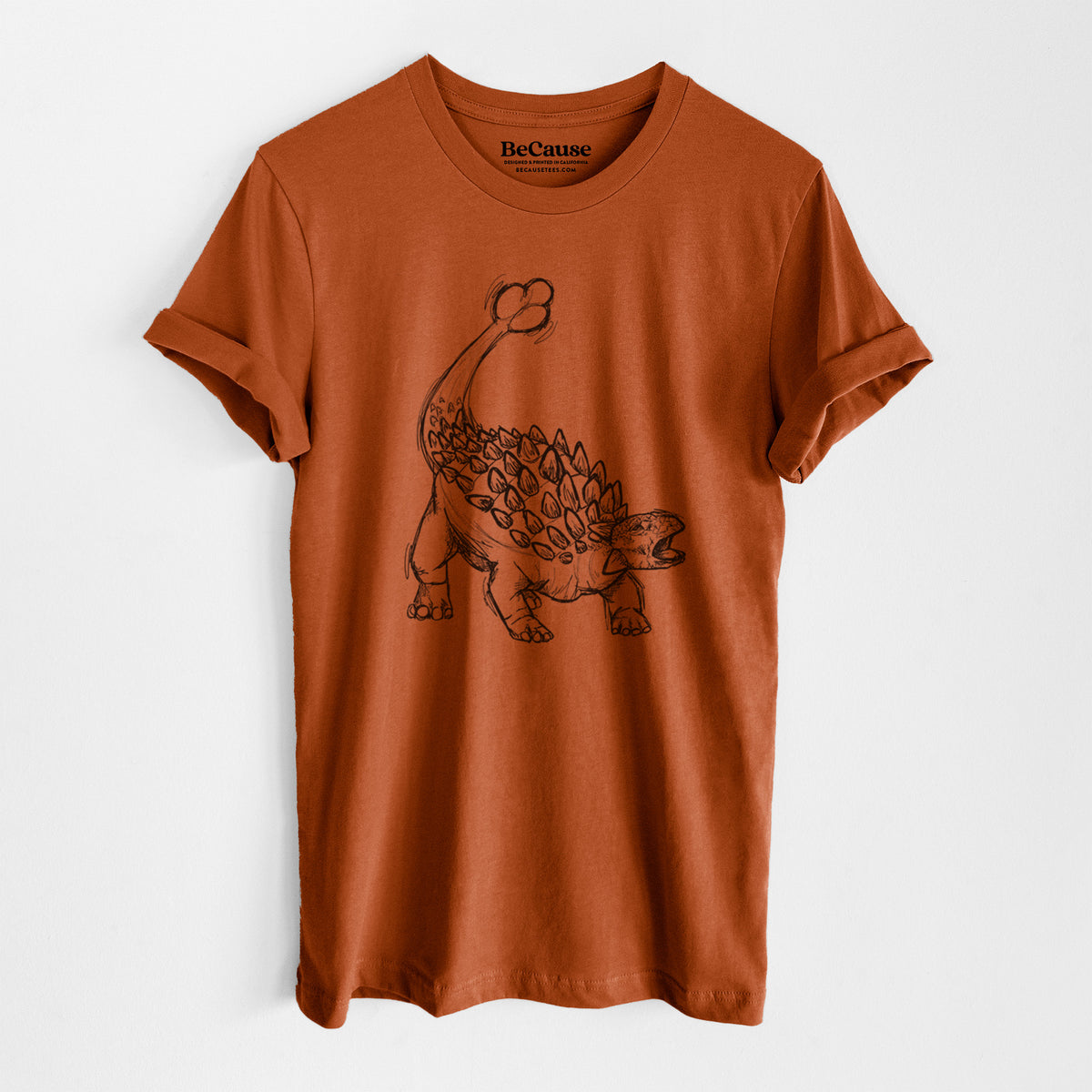 Autumn lightweight cotton t-shirt laid flat, printed with a black ink illustration of an Ankylosaurus with its club tail raised.
