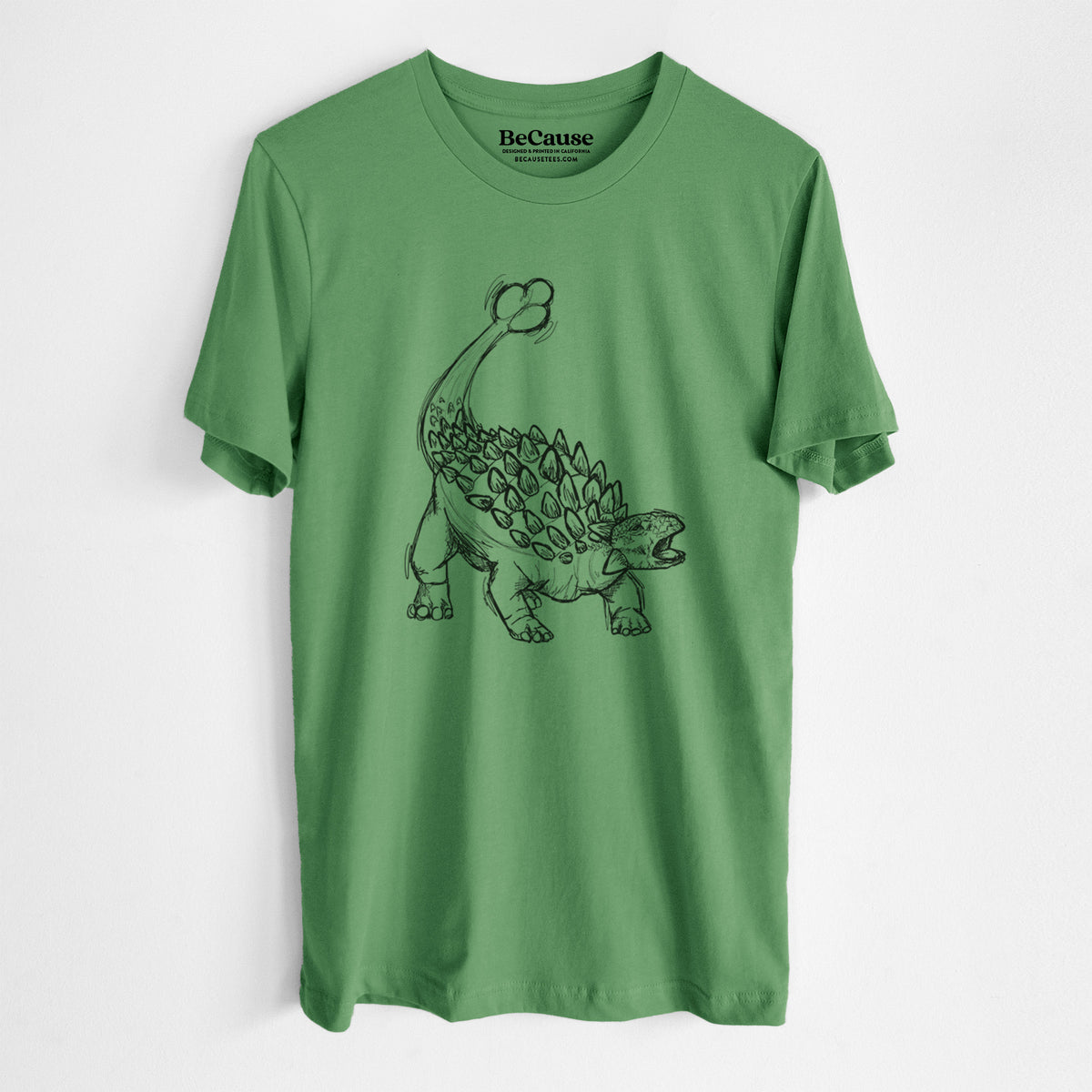 Leaf green lightweight cotton t-shirt laid flat, printed with a black ink illustration of an Ankylosaurus with its club tail raised.