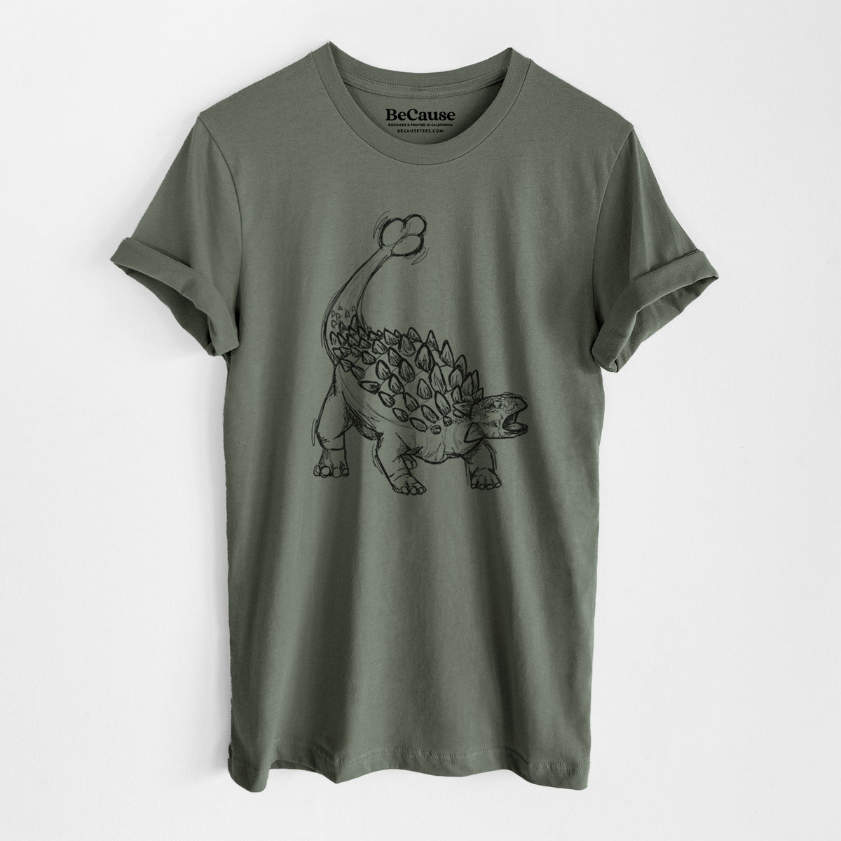 Military green lightweight cotton t-shirt laid flat, printed with a black ink illustration of an Ankylosaurus with its club tail raised.