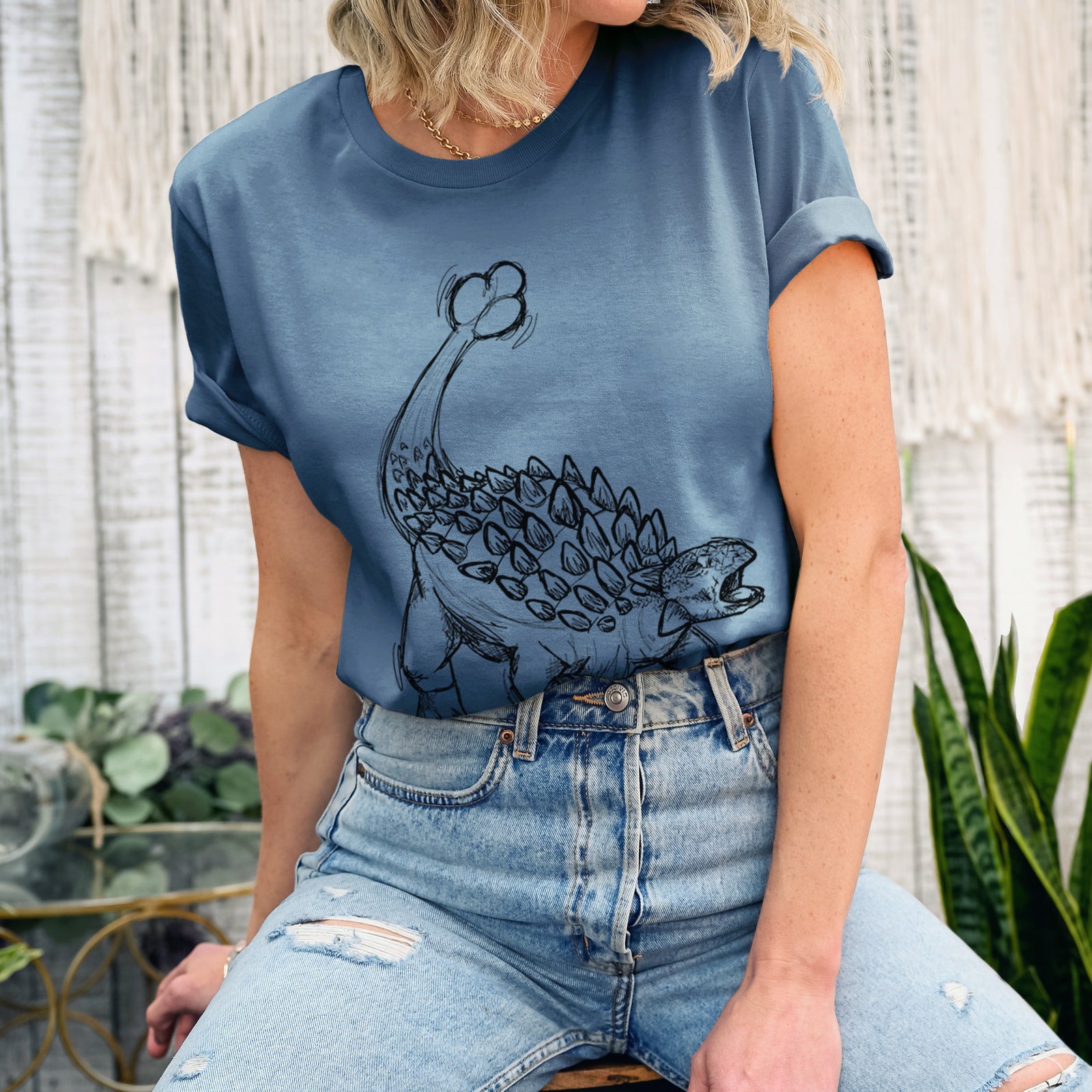 Autumn lightweight cotton t-shirt laid flat, printed with a black ink illustration of an Ankylosaurus with its club tail raised.
