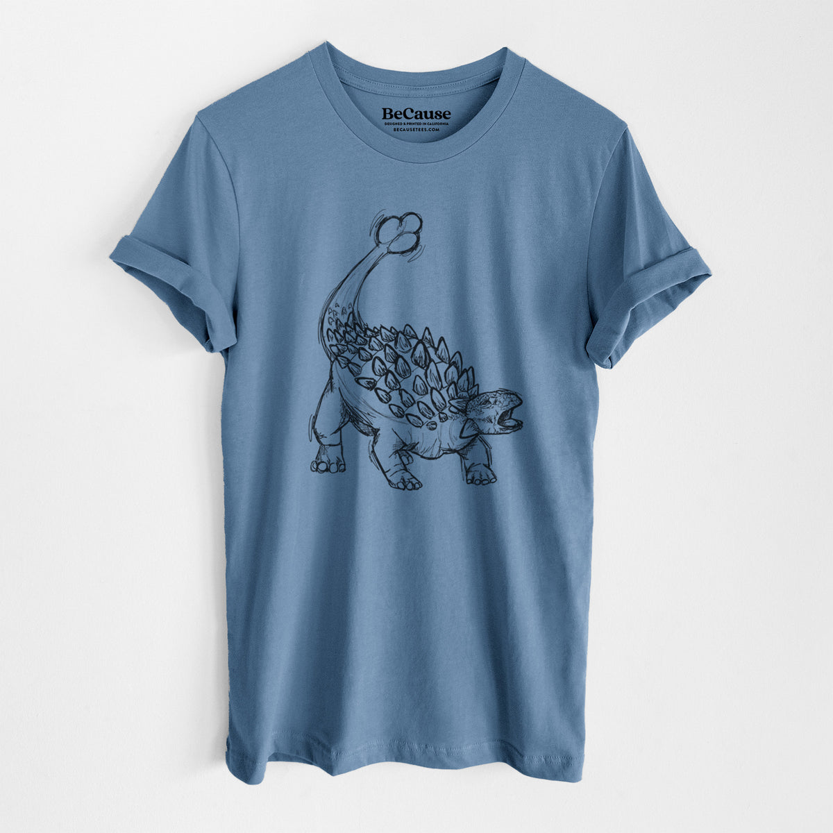 Steel blue lightweight cotton t-shirt laid flat, printed with a black ink illustration of an Ankylosaurus with its club tail raised.