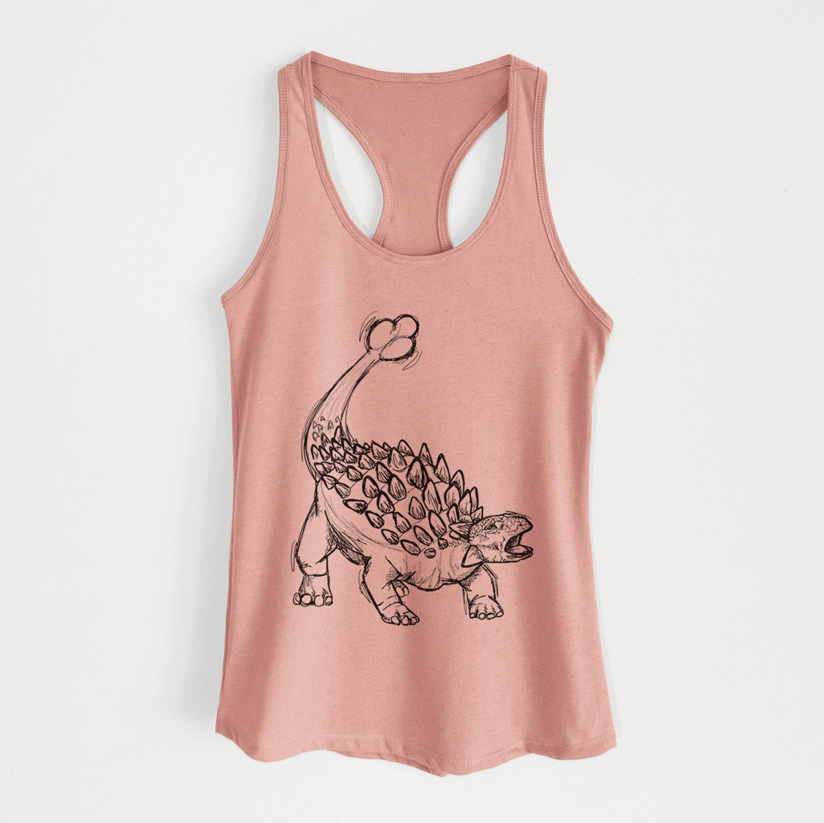 Desert pink women's racerback tank top laid flat, printed with a black ink illustration of an Ankylosaurus with its club tail raised.