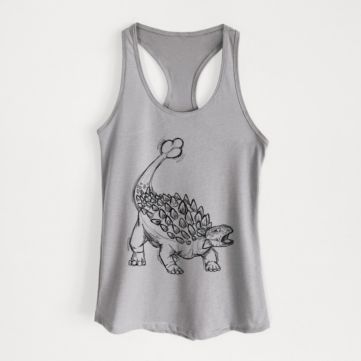 Heather grey women's racerback tank top laid flat, printed with a black ink illustration of an Ankylosaurus with its club tail raised.