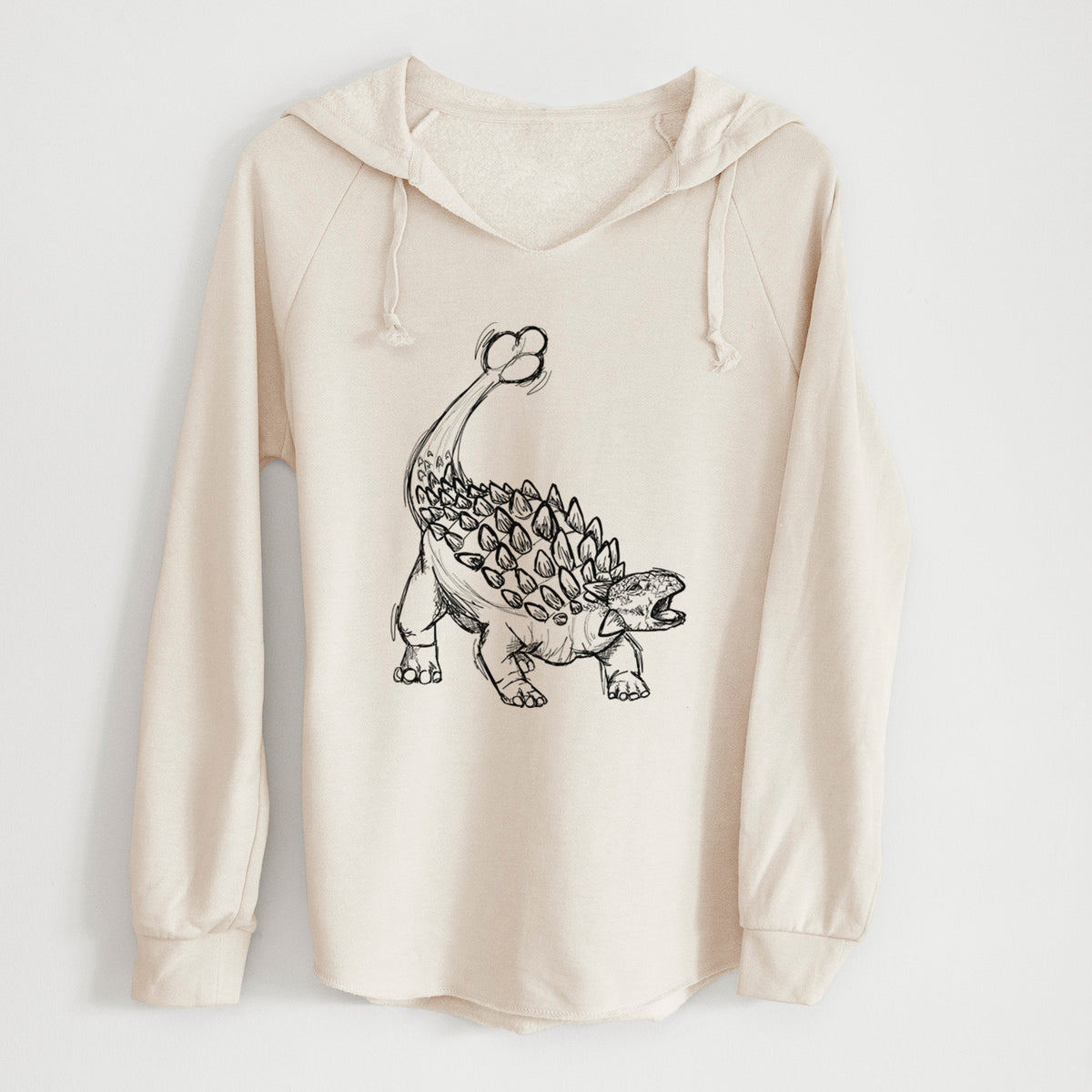 Bone cream women's Cali Wave hooded sweatshirt laid flat, printed with a black ink illustration of an Ankylosaurus with its club tail raised.
