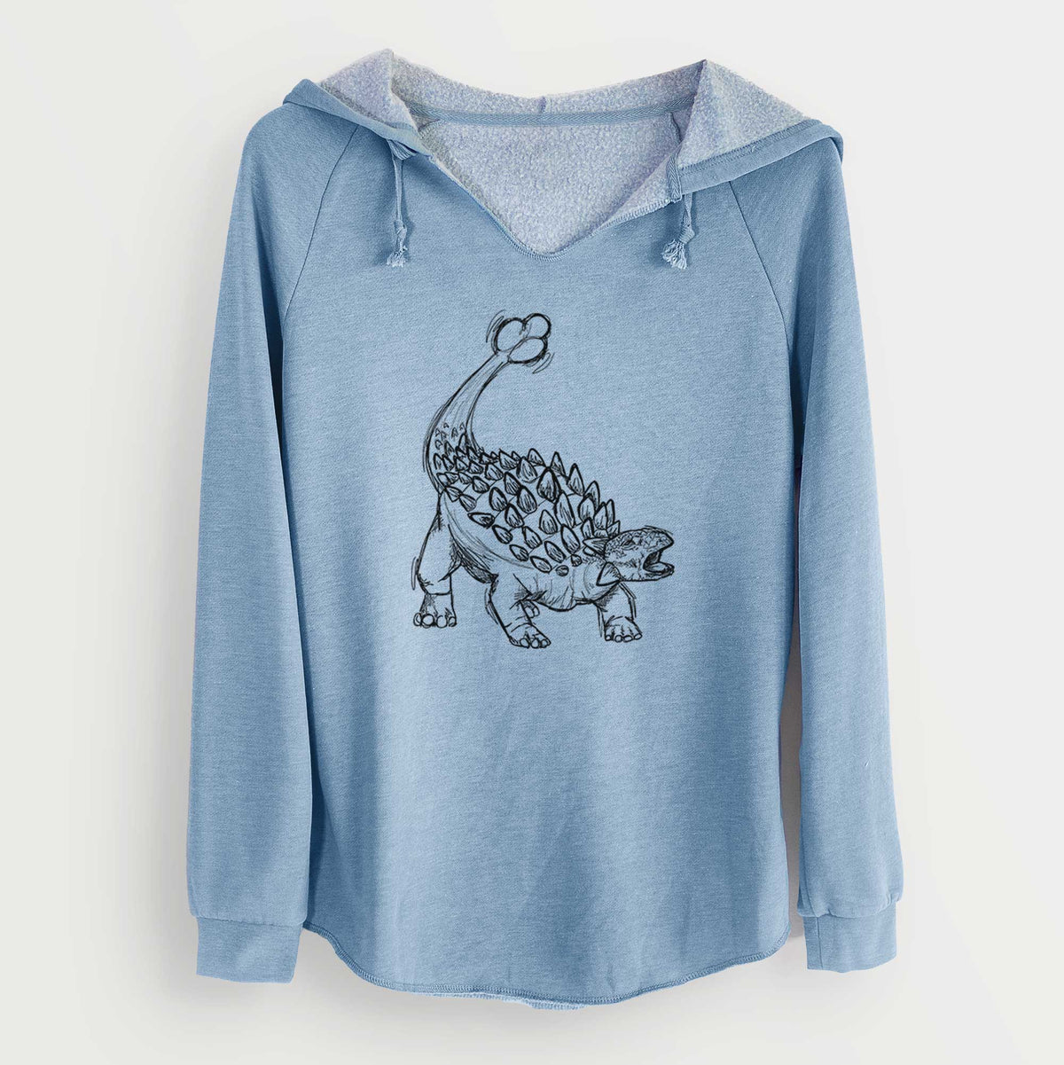 Misty blue women's Cali Wave hooded sweatshirt laid flat, printed with a black ink illustration of an Ankylosaurus with its club tail raised.