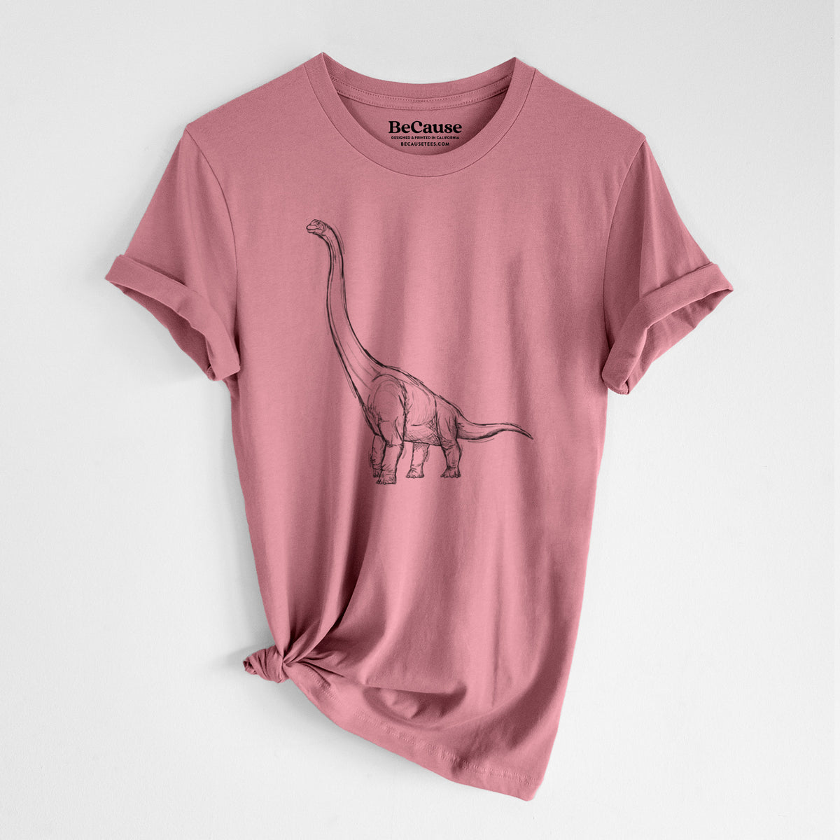 Mauve pink lightweight cotton t-shirt laid flat with the sleeves rolled, printed with a black ink illustration of a long-necked Apatosaurus walking.