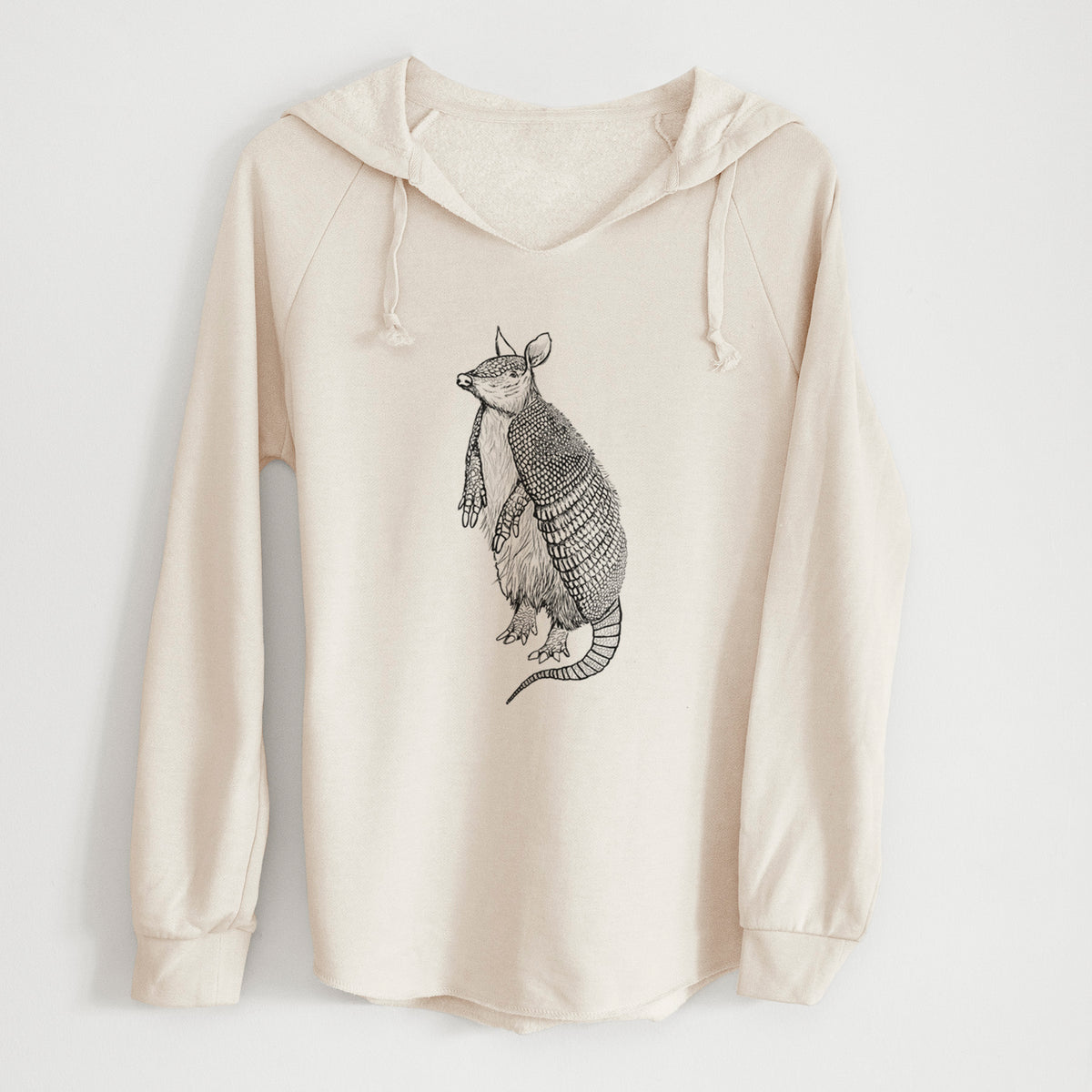 Bone cream women's Cali Wave hooded sweatshirt laid flat, printed with a black ink illustration of a nine-banded armadillo standing upright.