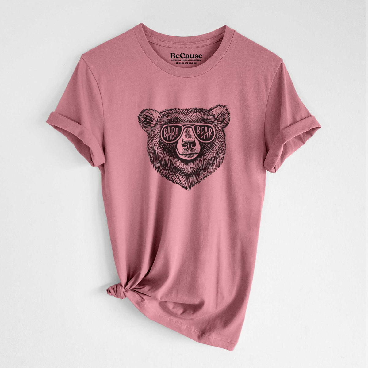 Mauve pink lightweight cotton t-shirt laid flat with the sleeves rolled, printed with a black ink bear's face wearing sunglasses that read Baba Bear.