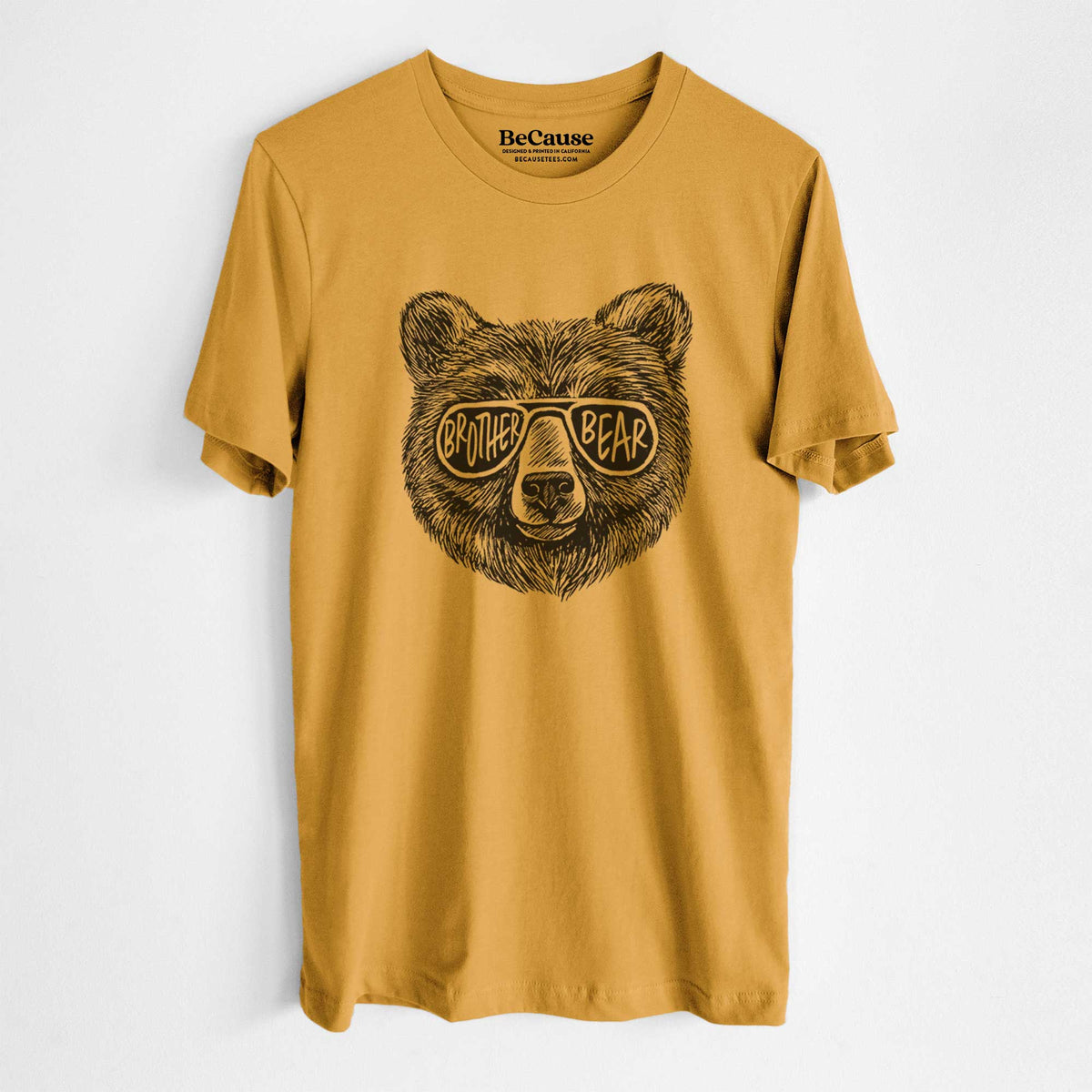 Mustard yellow lightweight cotton t-shirt laid flat, printed with a black ink bear's face wearing sunglasses that read Brother Bear.