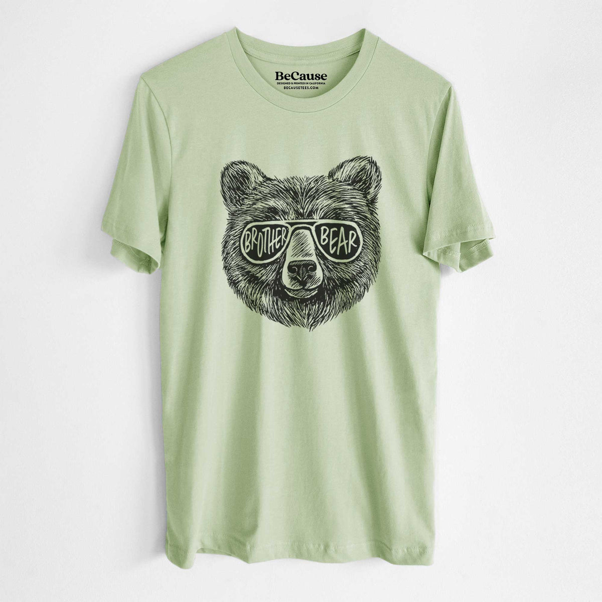 Spring green lightweight cotton t-shirt laid flat, printed with a black ink bear's face wearing sunglasses that read Brother Bear.