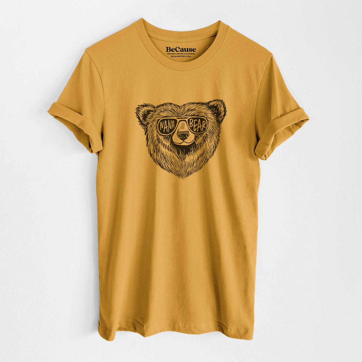 Mustard yellow lightweight cotton t-shirt laid flat, printed with a black ink bear's face wearing sunglasses that read Nana Bear.