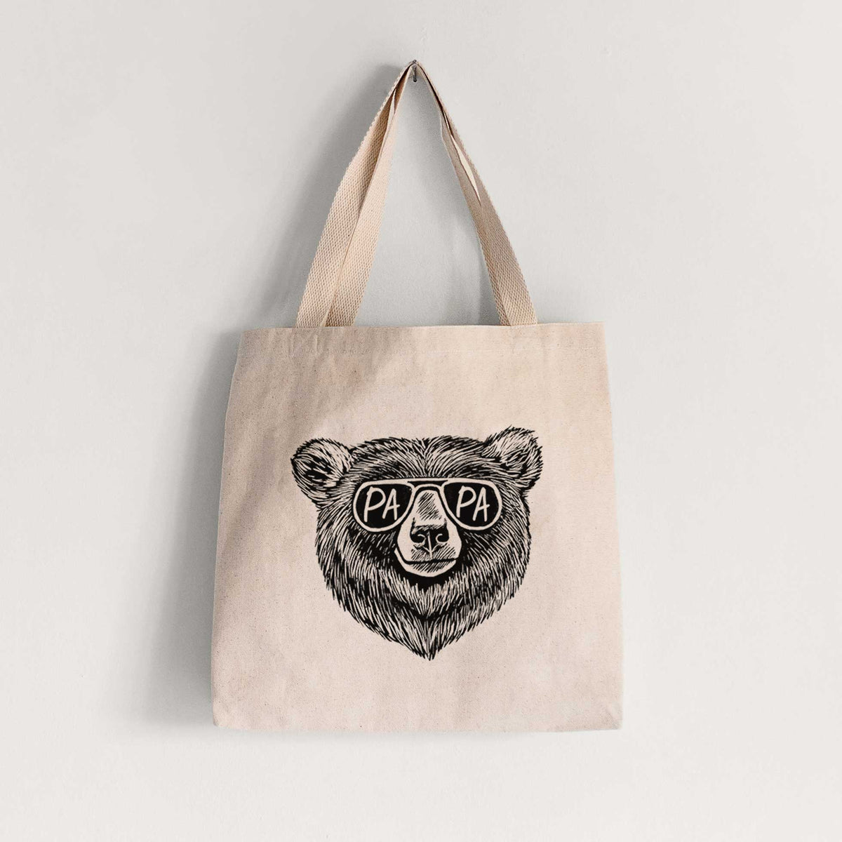 Natural canvas tote bag printed with a black ink bear's face wearing sunglasses that read Papa.