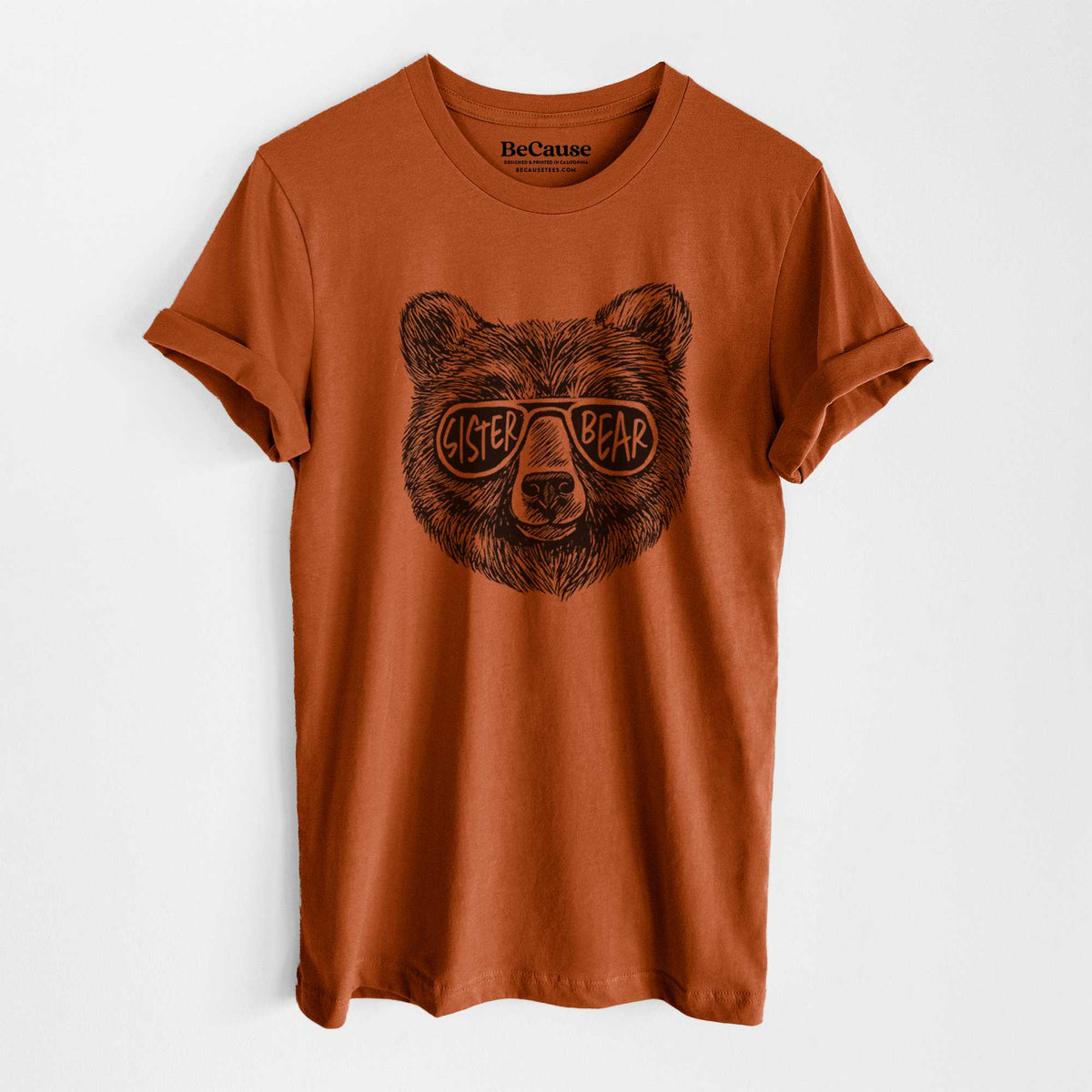 Autumn lightweight cotton t-shirt laid flat, printed with a black ink bear's face wearing sunglasses that read Sister Bear.