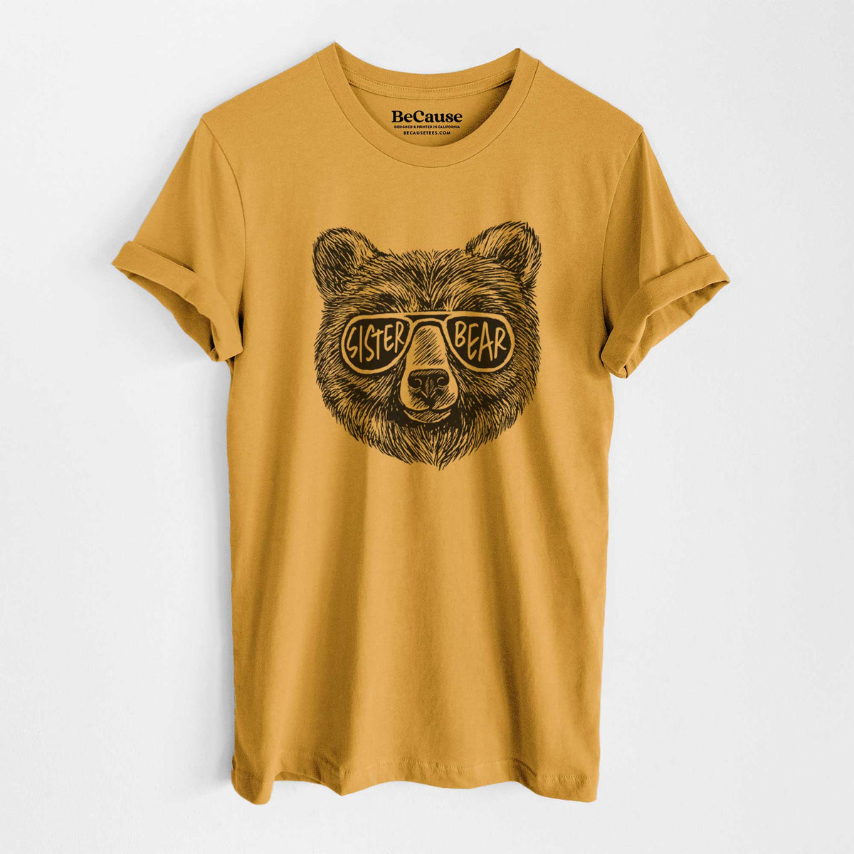 Mustard yellow lightweight cotton t-shirt laid flat, printed with a black ink bear's face wearing sunglasses that read Sister Bear.