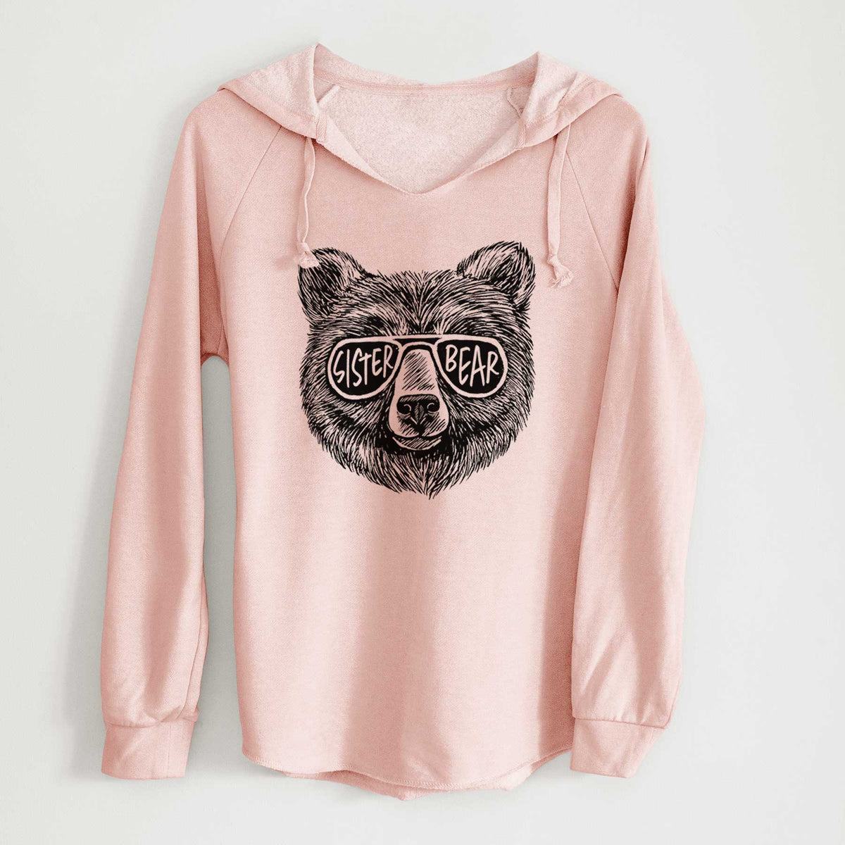 Blush pink women's Cali Wave hooded sweatshirt laid flat, printed with a black ink bear's face wearing sunglasses that read Sister Bear.