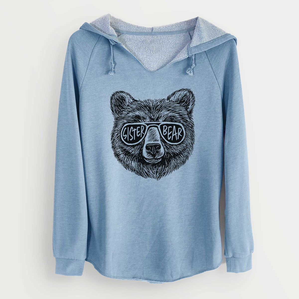 Misty blue women's Cali Wave hooded sweatshirt laid flat, printed with a black ink bear's face wearing sunglasses that read Sister Bear.