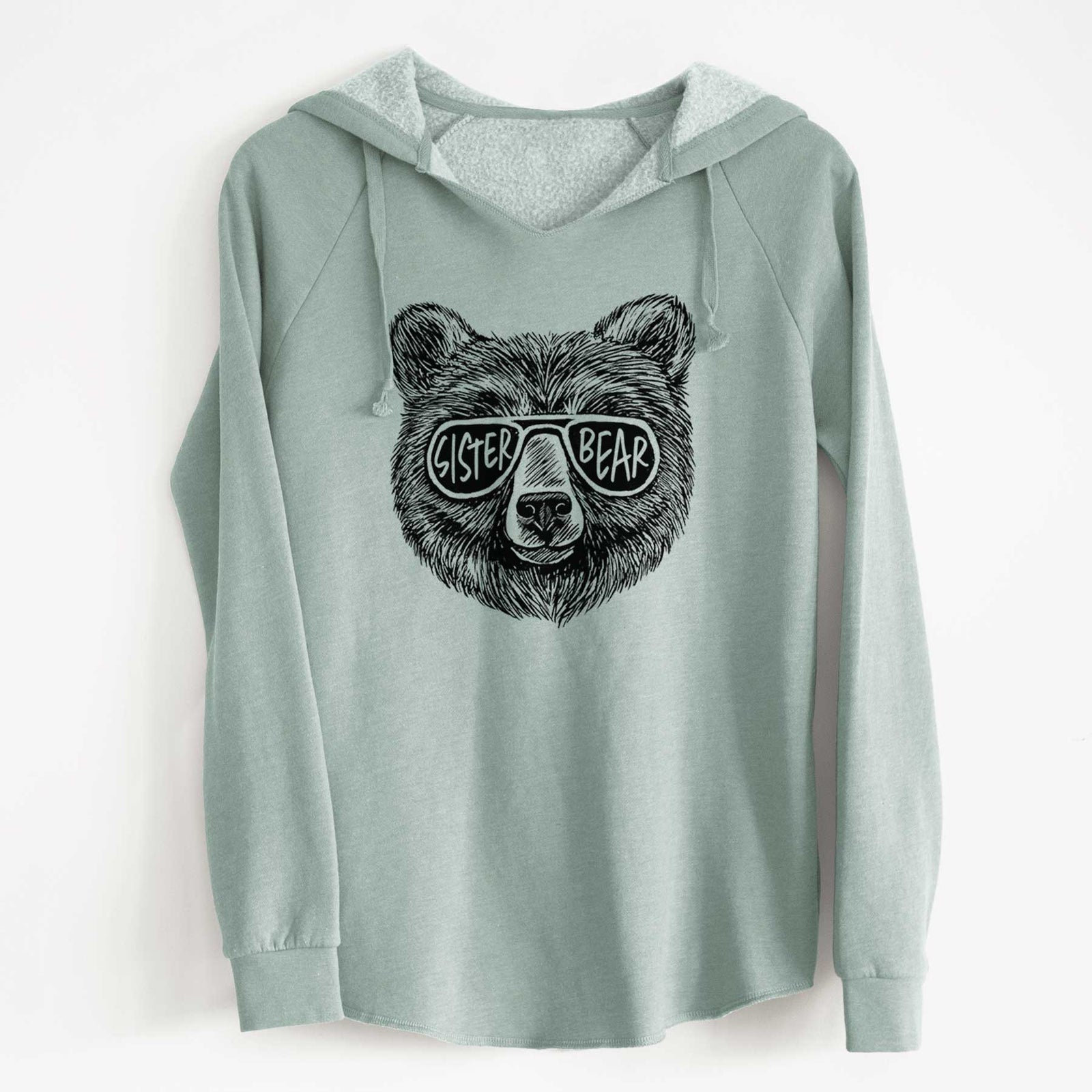 Sage green women's Cali Wave hooded sweatshirt laid flat, printed with a black ink bear's face wearing sunglasses that read Sister Bear.