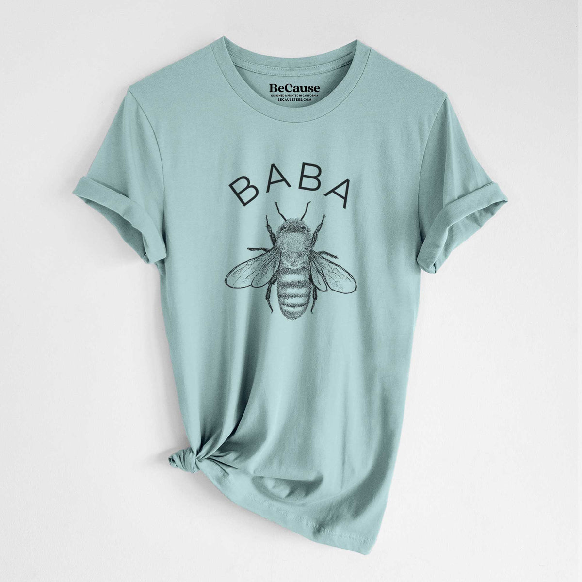 Dusty blue lightweight cotton t-shirt laid flat with the sleeves rolled, printed with a black ink honey bee beneath the word Baba.