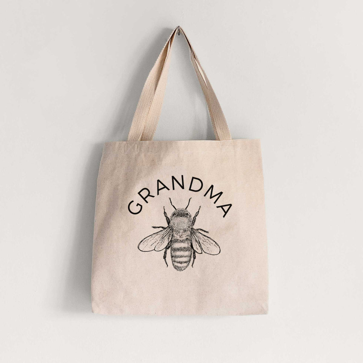 Natural canvas tote bag printed with a black ink honey bee beneath the word Grandma.