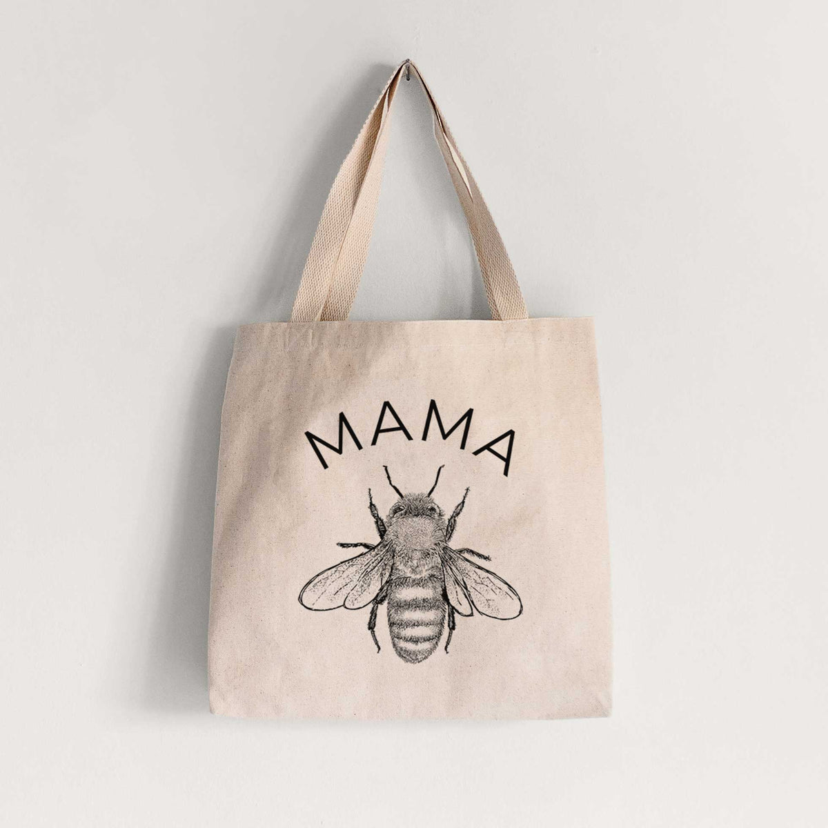 Natural canvas tote bag printed with a black ink honey bee beneath the word Mama.