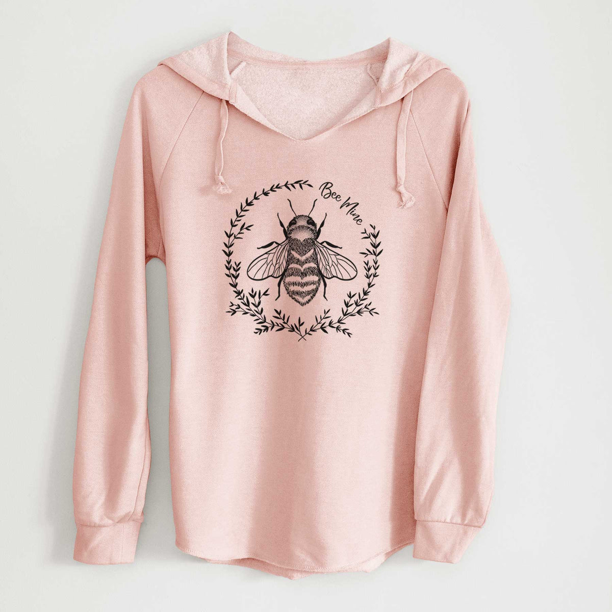 Blush pink women's Cali Wave hooded sweatshirt laid flat, printed with a black ink bee inside a wreath of leaves with the words Bee Mine.