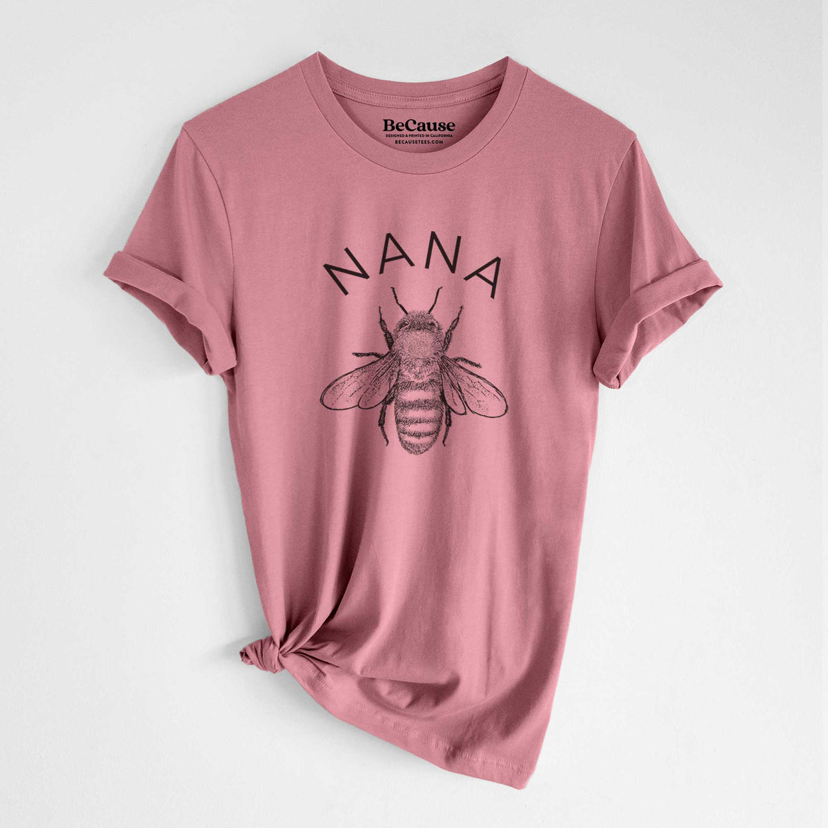 Mauve pink lightweight cotton t-shirt laid flat with the sleeves rolled, printed with a black ink honey bee beneath the word Nana.