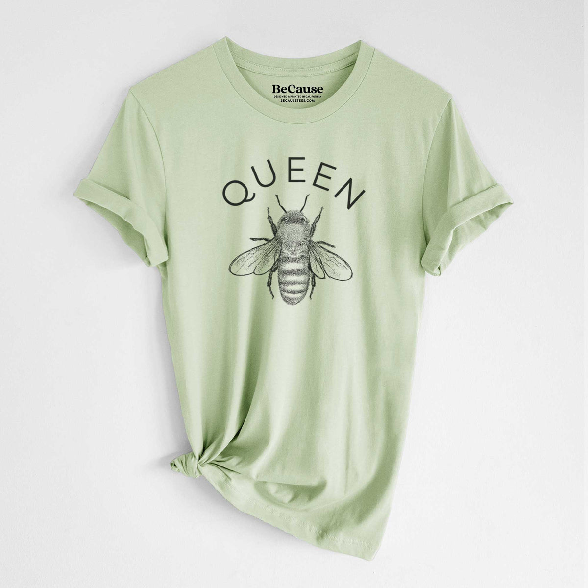 Spring green lightweight cotton t-shirt laid flat with the sleeves rolled, printed with a black ink honey bee beneath the word Queen.