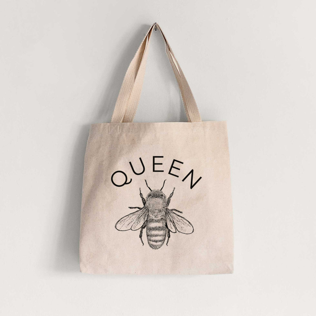 Natural canvas tote bag printed with a black ink honey bee beneath the word Queen.
