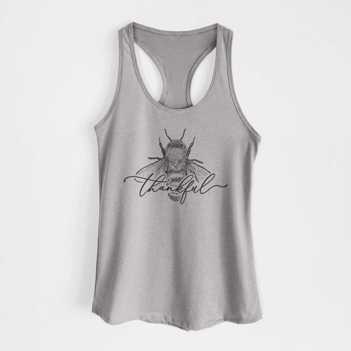 Heather grey women's racerback tank top laid flat, printed with a black ink bee with the word thankful written in script across it.