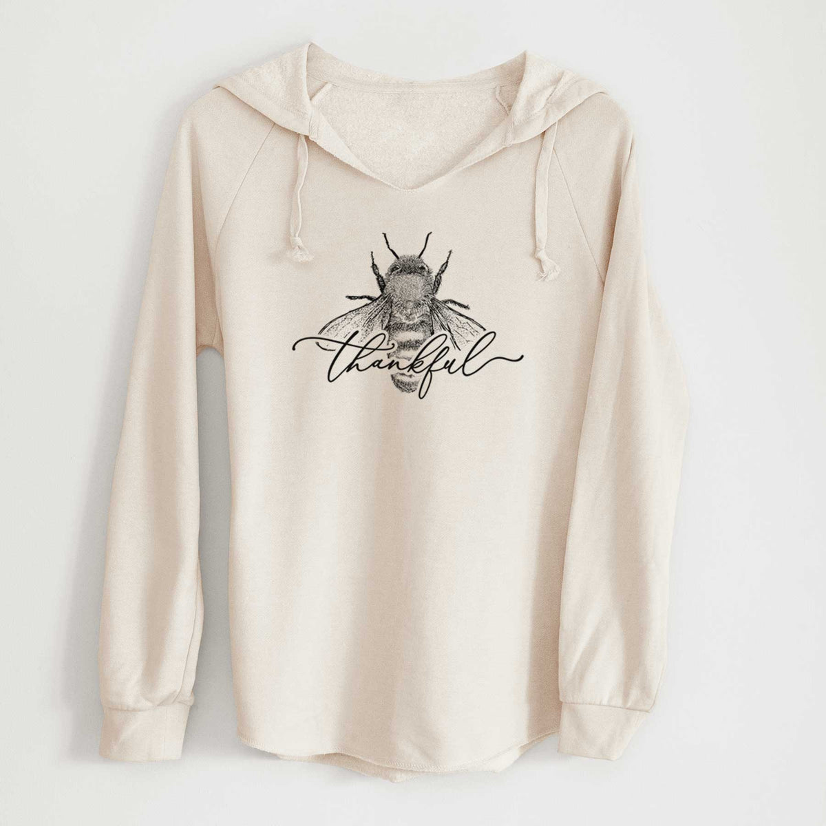 Bone cream women's Cali Wave hooded sweatshirt laid flat, printed with a black ink bee with the word thankful written in script across it.