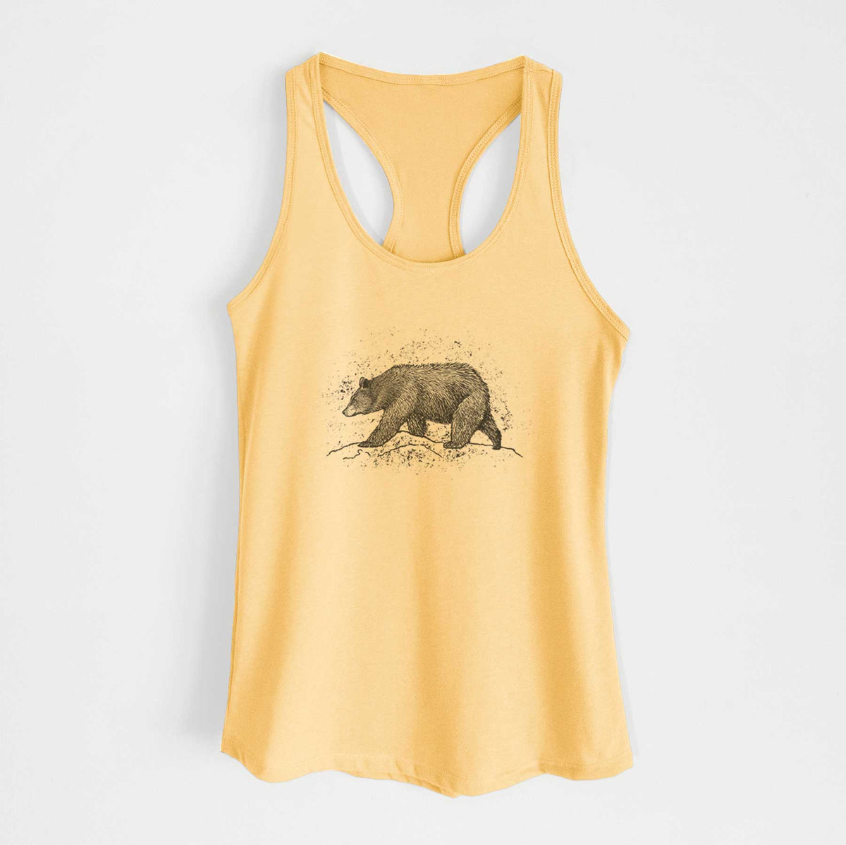 Banana cream women's racerback tank top laid flat, printed with a detailed black ink sketch of a black bear walking across rocky ground.