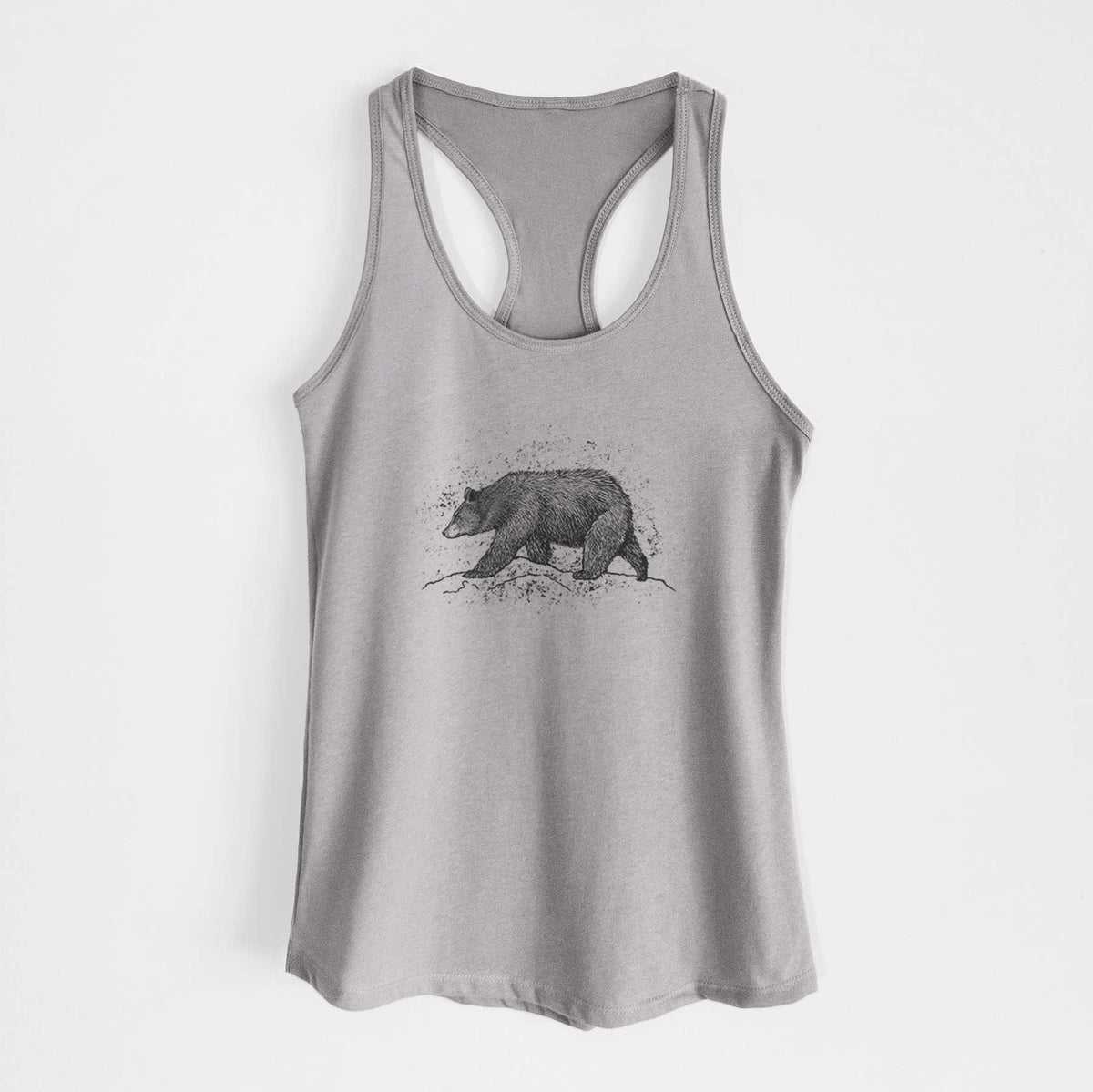 Heather grey women's racerback tank top laid flat, printed with a detailed black ink sketch of a black bear walking across rocky ground.