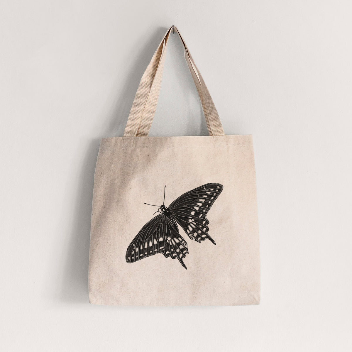 Natural canvas tote bag printed with a detailed black ink illustration of a black swallowtail butterfly with its wings spread.