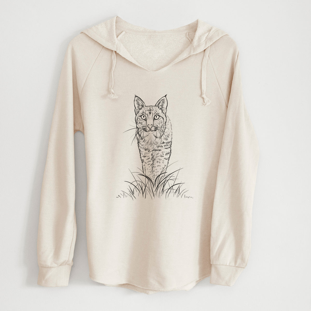 Bone cream women's Cali Wave hooded sweatshirt laid flat, printed with a black ink illustration of a bobcat standing in tall grass, facing forward.