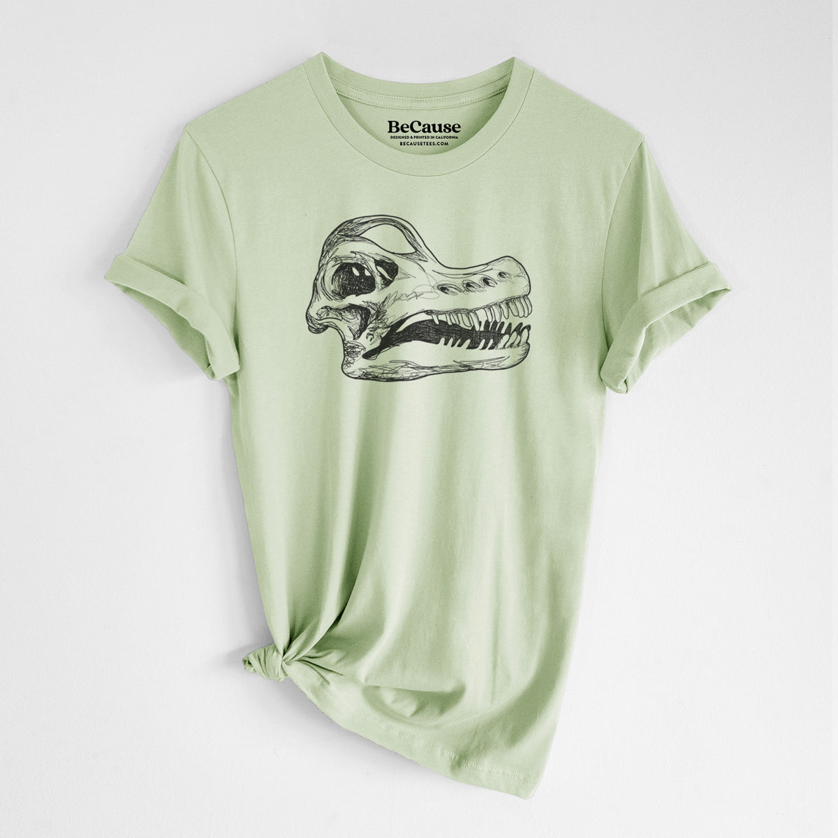 Spring green lightweight cotton t-shirt laid flat with the sleeves rolled, printed with a detailed black ink illustration of a Brachiosaurus skull.