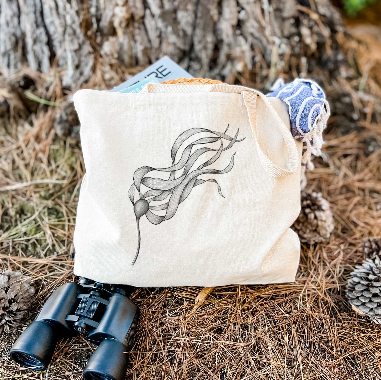 Natural canvas tote bag printed with a black ink line drawing of a strand of bull kelp with long flowing blades.