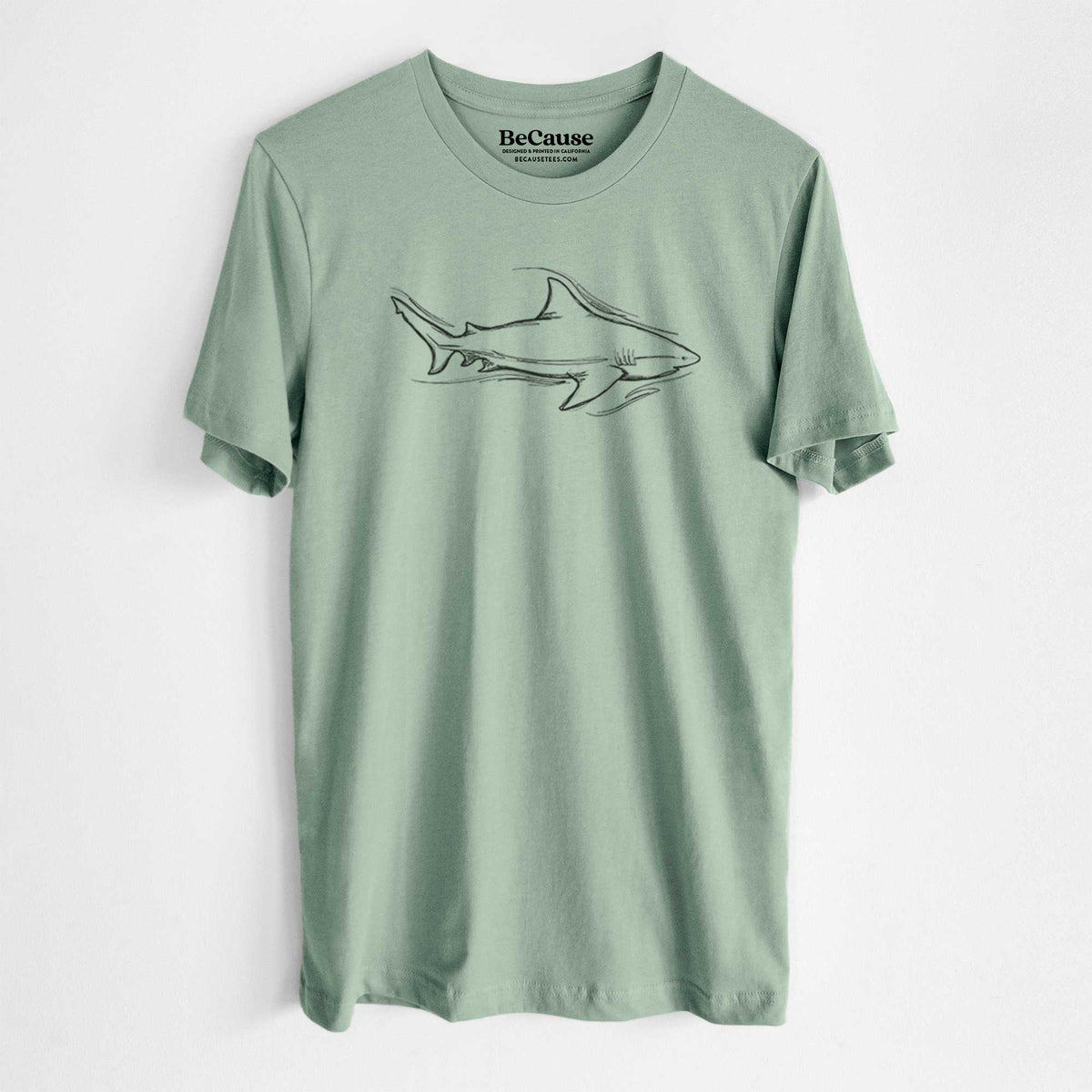 Sage green lightweight cotton t-shirt laid flat, printed with a black ink illustration of a bull shark swimming.